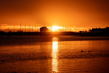 sun setting over the sea with Langstone bridge in the background	
