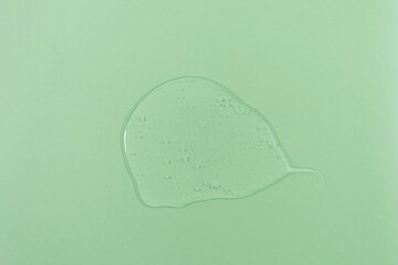 The texture of serum or oil on a green background. Wellness and beauty concept