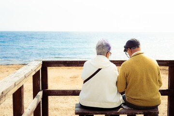 Two ancient people in front of the sea. Elderly people in Spain coast.