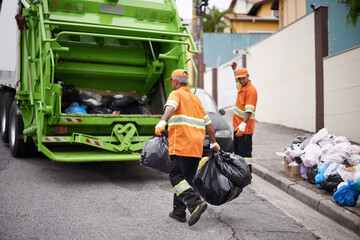 One street at a time.... Cropped shot of a garbage collection team at work.