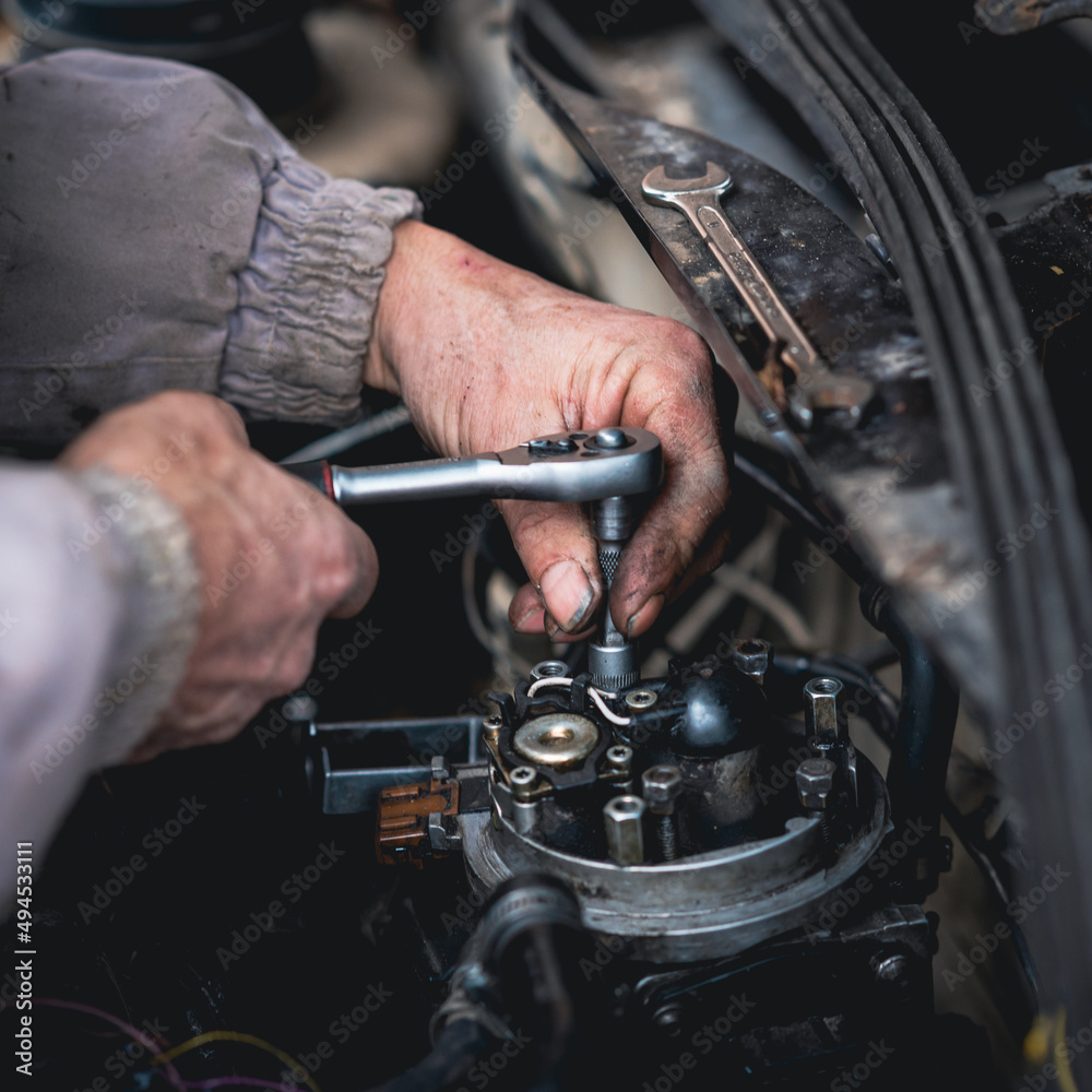 Wall mural closeup of a man repairing the car engine