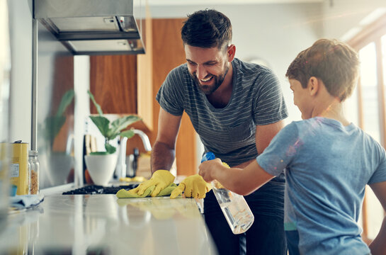 The super disinfecting son and dad duo. Shot of a father and son cleaning the kitchen counter together at home.