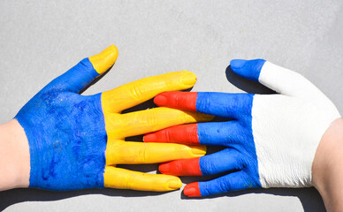 hands of russian and ukrainian flags colors, symbol of truce and consent between Russia and...
