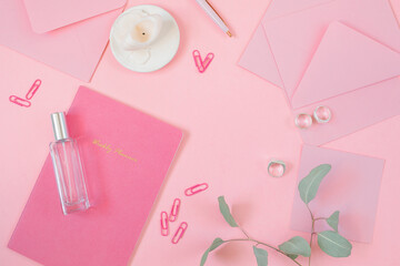 Office supply items on pink work desk. Top view, flat lay.