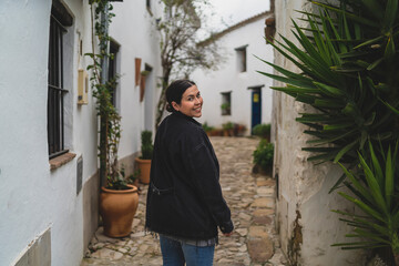 Chica joven guapa paseando y sonriendo por pueblo blando andaluz 