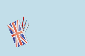 pencil case on desk with a pencil on blue. british english union jack flag. Flat lay with copy...