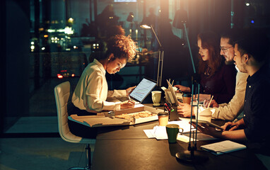 This team puts in all the work. Cropped shot of young employees working late into the evening.