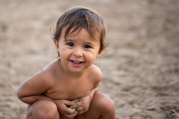 Portrait of cute little girl play with sand on the beach