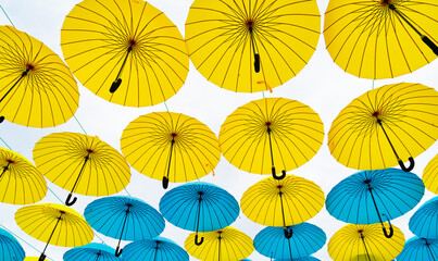 Fototapeta na wymiar Multicolored umbrella sky background. Hanging street decoration bottom-up