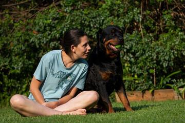 Wife Cuddling a teddy bear Rottweiler. Positive emotions showing the attachment between wife and pet love and trust and absolute endearment