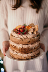 Vertical shot of a female holding a delicious creamy cake © Stefan Radosavljevic/Wirestock Creators
