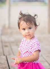 Portrait of cute little girl with pink dress on the beach.