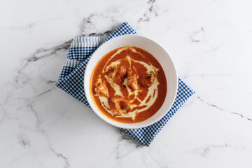 Traditional indian food Murgh Makhani or Butter chicken, tikka masala in a dish isolated on napkin side view on grey background - obrazy, fototapety, plakaty