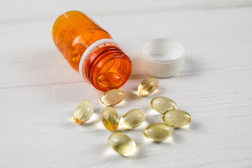 pills from a jar on white.