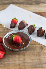Strawberries with chocolate. Strawberry perched in the chocolate bowl. Copy space.