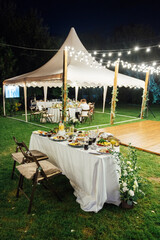 Wedding. Banquet. The chairs and round table for guests, served with cutlery. Evening time