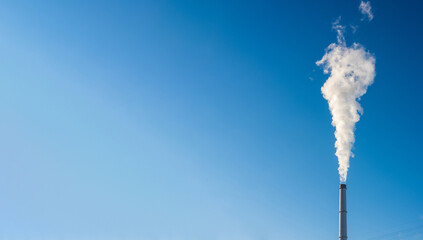 chimney of a Coal-fired power plant is blowing a ton of steam and Greenhouse gas into the blue sky. - Powered by Adobe