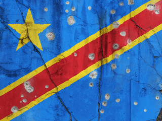 Full frame photo of a weathered flag of Democratic Republic of the Congo painted on a cracked wall with bullet holes. Violence in the Democratic Republic of the Congo concept.