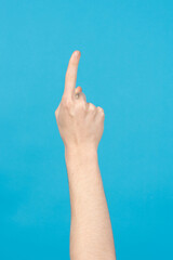 Finger pointing up on blue background.