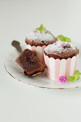 Chocolate cupcake on a white plate and on a white background, pastry shop, free space for text
