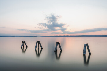 Sunset Impression of wooden pillars at Lake Neusiedl (Podersdorf am See, Burgenland, Austria)