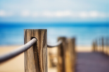 Selective focus shot of Wooden poles with a rope on the edge of a walkway