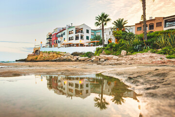 Fototapeta premium Beautiful white houses, mediterranean sea and a clear blue sky in the setting sun and sunset in El Roc de Sant Gaieta, Catalonia