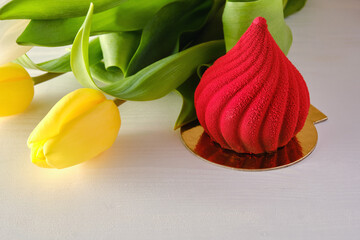 Red, bright dessert with yellow tulips on a white background.