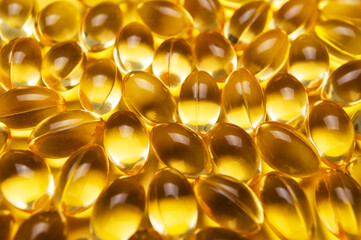 Capsules pill with vitamin D on yellow background close-up. Fish oil, Omega, Omega-3, dietary supplement, sunshine vitamin. Healthy lifestyle, medicine, cosmetology, diet. Pharmaceutical concept