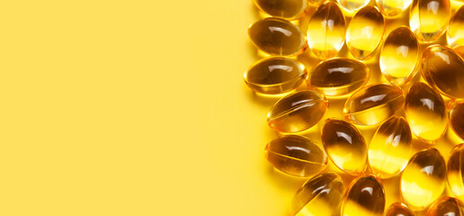 Capsules pill with vitamin D on yellow background close-up. Fish oil, Omega, Omega-3, dietary supplement, sunshine vitamin. Healthy lifestyle, medicine, cosmetology, diet. Pharmaceutical concept