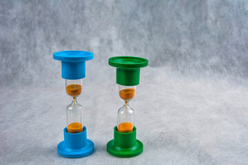 Time concept .Blue sand hourglass on vintage background