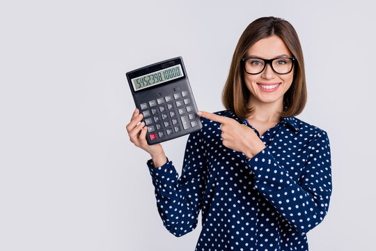 Portrait of attractive cheerful girl demonstrating number calculator cash savings isolated over grey pastel color background