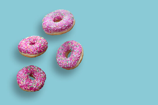 Creative food concept: levitating dounuts isolated on blue background.