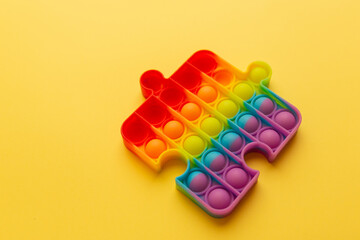 Rainbow Square Fidget Toy Pop-it on the yellow background. Popular Relaxing square shape silicone stress relief toy
