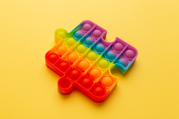 Rainbow Square Fidget Toy Pop-it on the yellow background. Popular Relaxing square shape silicone stress relief toy