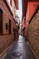 Fototapeta na wymiar Narrow street in the Turkish city of Antalya, Turkey, city street, buildings, paving stones, vertical photo.