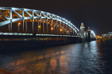 Naklejka premium the beautiful metal bridge of Peter the Great across the Neva River in St. Petersburg against the night sky