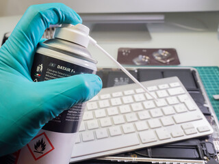 Man's hand with compressed air spray. Selective focus.