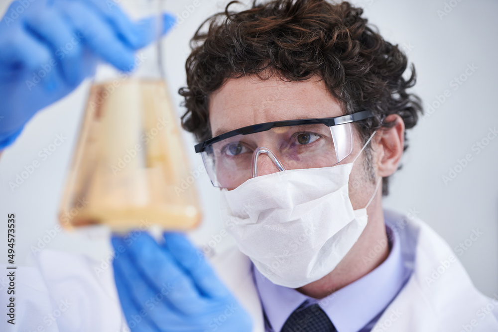 Poster What could this mean. A cropped shot of a scientist examining a flask filled with liquid.