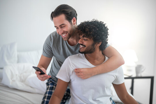 Romantic gay couple posing for the smartphone camera