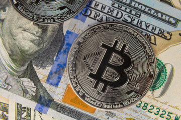 bitcoin coin flying on hundred dollar bill close up