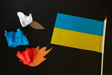 Ukraine flag and aggression. Black background. Top view, flat lay