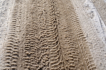 Tire traces in snow. Spring slush. Ground covered with thawing snow and car trace. Snowy road with car traces