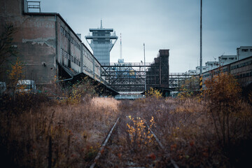 An old overgrown rail line leading into abandoned freight station in Prague
