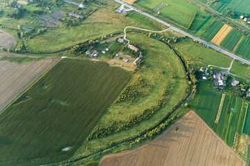 Aerial landscape view of green and yellow cultivated agricultural fields with growing crops on bright summer day