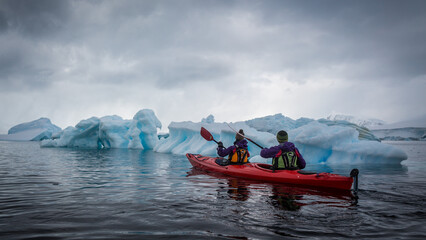 Abenteuer, mit dem roten Kanu durch die eisige Landschaft vorbei an dem blauen Eis der Antarktis
