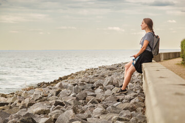 Beautiful girl on the sea with blue sky and clouds