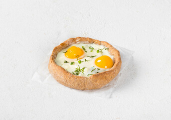 Small rye cottage cheese open pie with mozzarella, quail eggs and dill, on paper. Light background