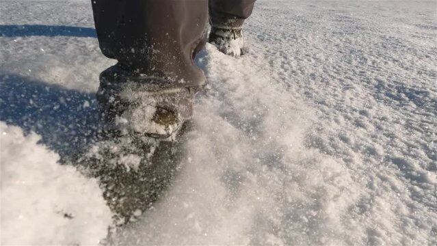 Walk on fresh snow in snow boots towards camera in cold winter sunny morning nature