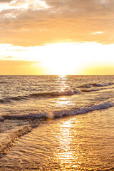 Sea waves on the seashore spill over the sandy sand in the evening at sunset